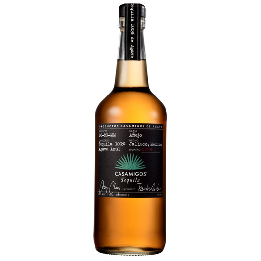 Casamigos Anejo Tequila in a tall clear glass bottle of amber barrel-aged tequila with a black neck and a black label featuring the blue agave emblem and Casamigos Tequila script