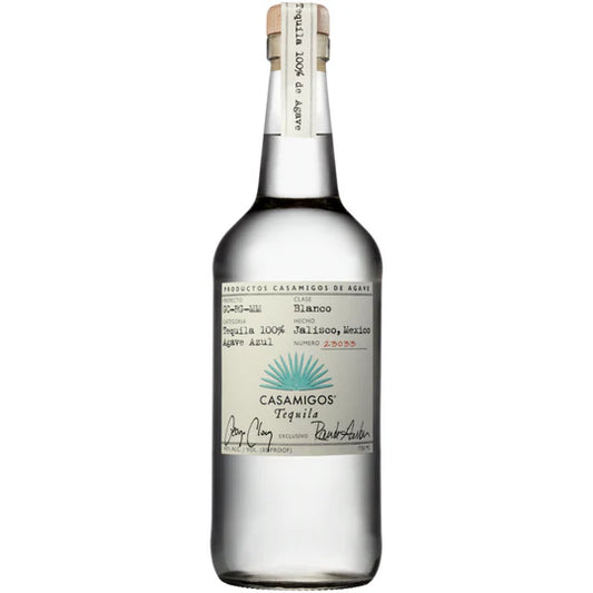 Casamigos Blanco Tequila in a tall clear glass bottle of clear tequila with a cork stopper and a white label featuring a blue agave illustration and Casamigos Tequila script