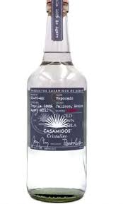 Casamigos Reposado Cristalino Tequila in a tall clear glass bottle of clear filtered tequila with a wooden cap and a silver and white label featuring the Casamigos agave emblem